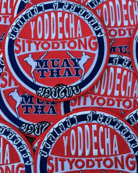 Stacks of red and blue embroidered club patches ready to ship.